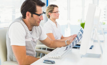 photo editor looking at a contact sheet in his office